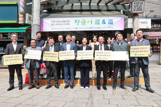 오영주(앞줄 왼쪽 5번째) 중소벤처기업부 장관과 이복현(앞줄 왼쪽 4번째) 금융감독원장이 11일 서울 종로구 통인시장에서 열린 '전통시장-금융회사 결연(장금이) 확대보고대회' 참석을 마치고 관계자들과 기념 촬영을 하고 있다. [중기부 제공]